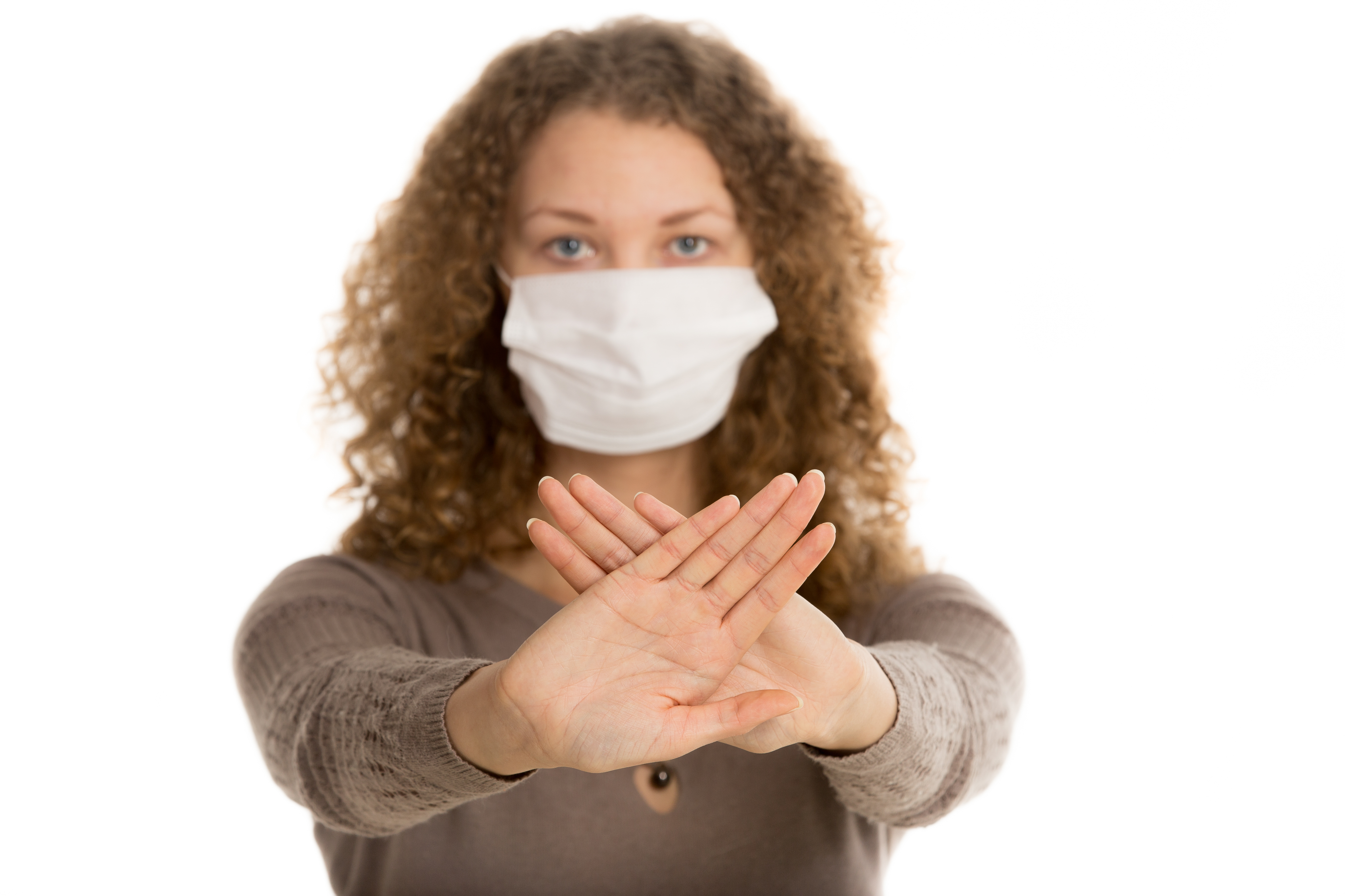 Girl in face mask stretch out palms in warning gesture with palms in focus