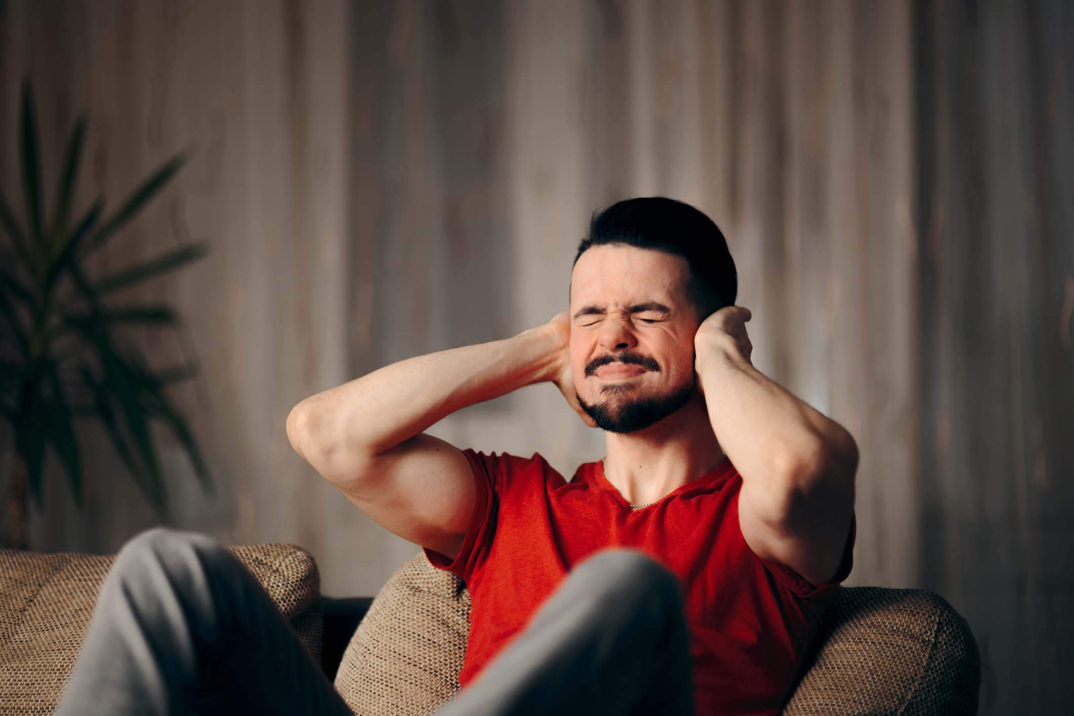 Desperate man trying to ignore loud neighbors