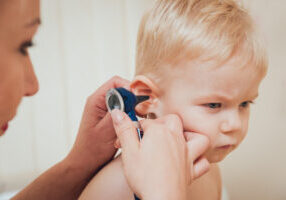 Doctor examines ear with otoscope in a pediatrician room. Medical equipment